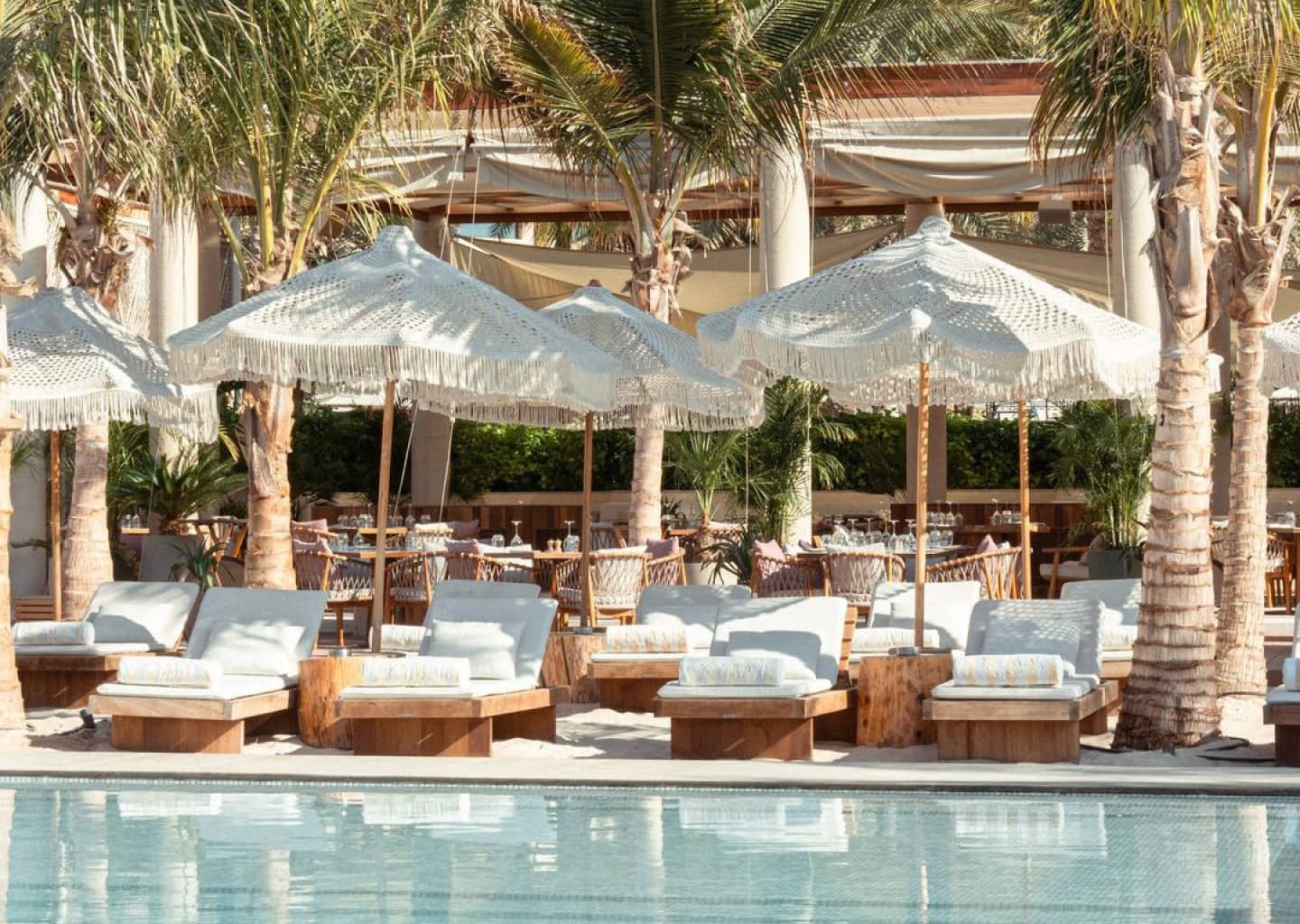 Fringed umbrellas and palms around Kyma Beach’s pool