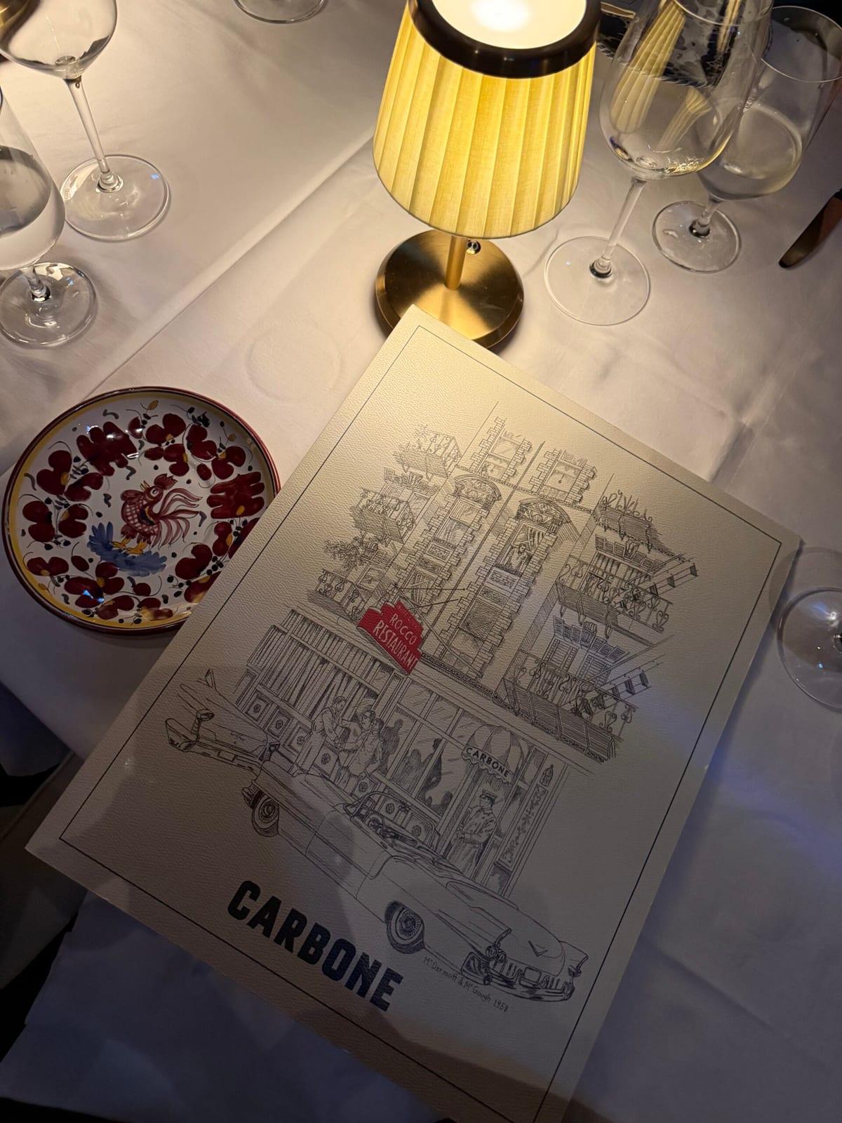 Carbone’s illustrated menu under the table lamp