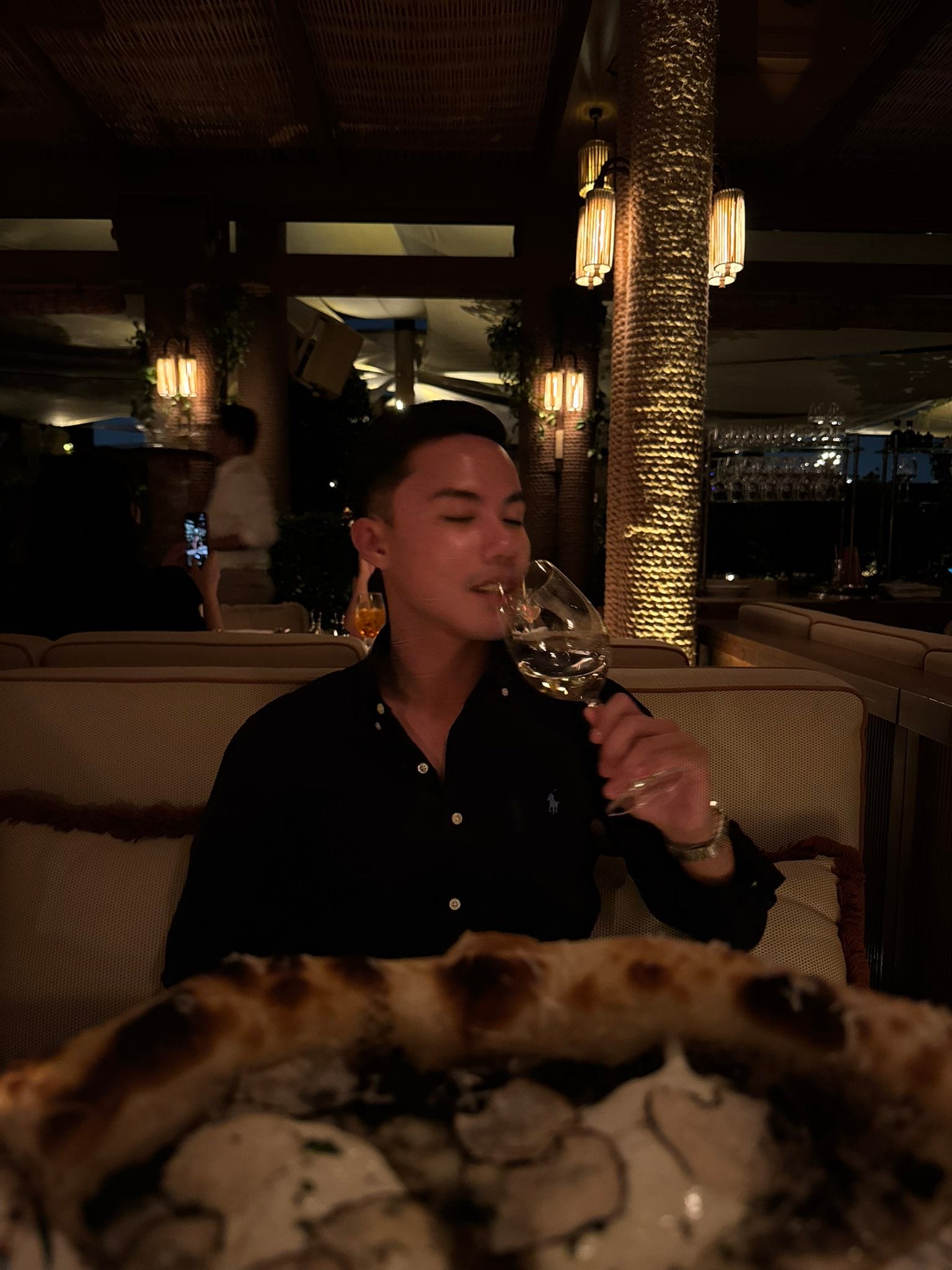 Aaron with a glass of white wine in a lantern-lit dining room