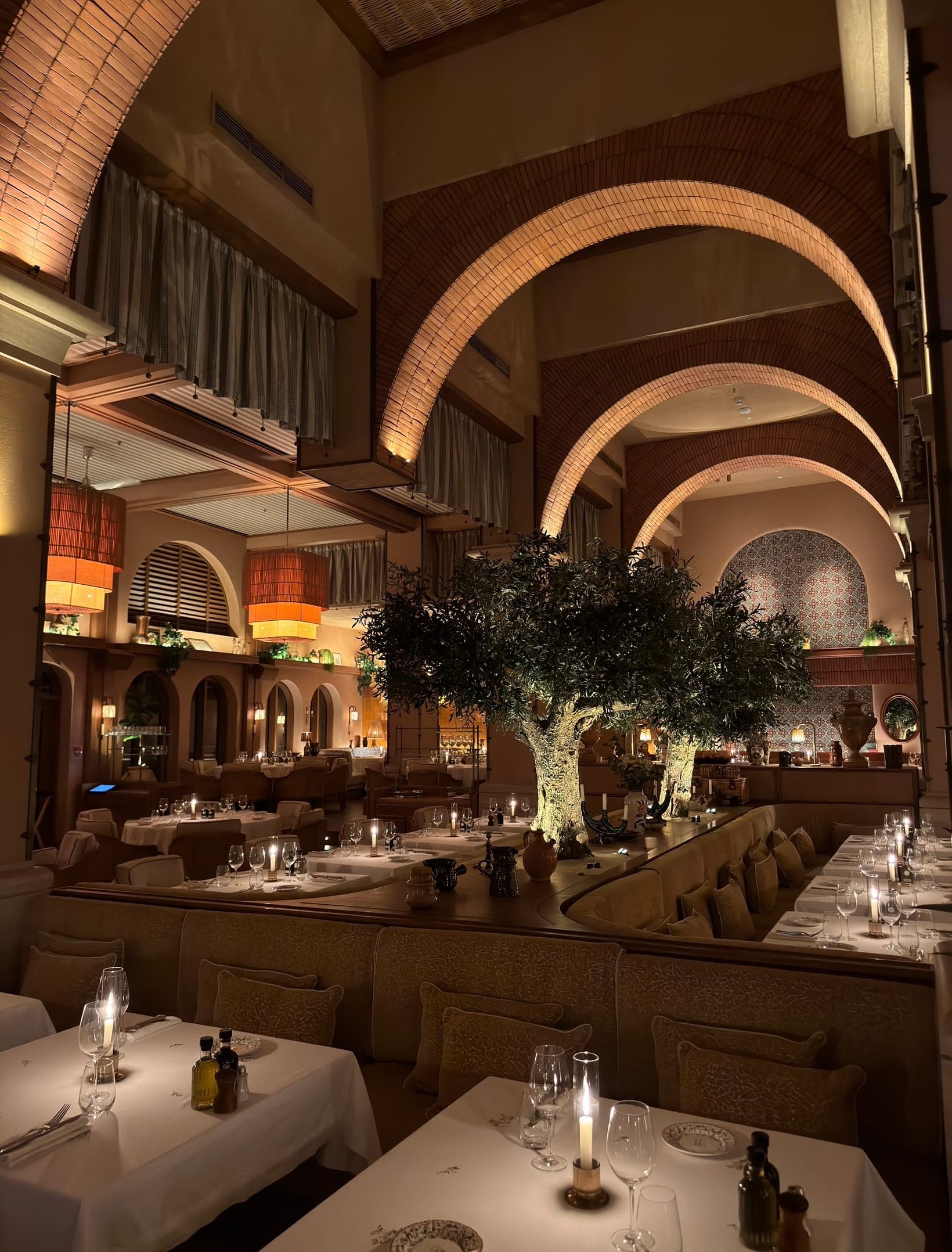 Candlelit tables under the arches and olive trees at Gigi Rigolatto