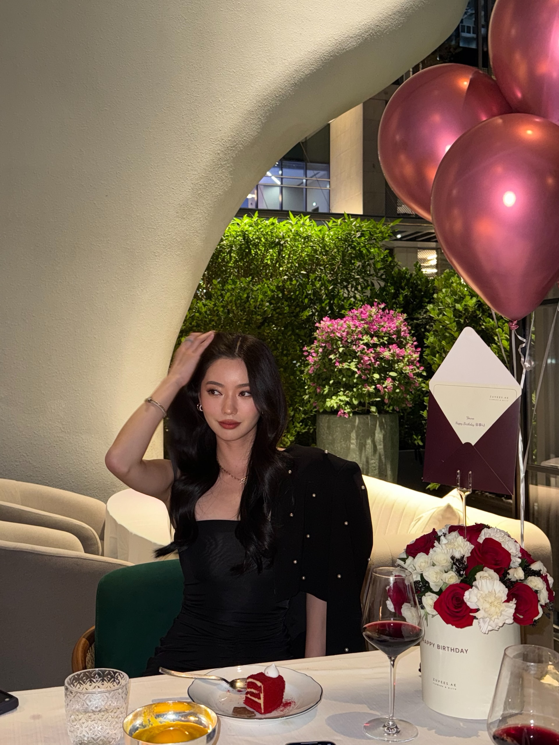 Vailey at a birthday table under pink balloons