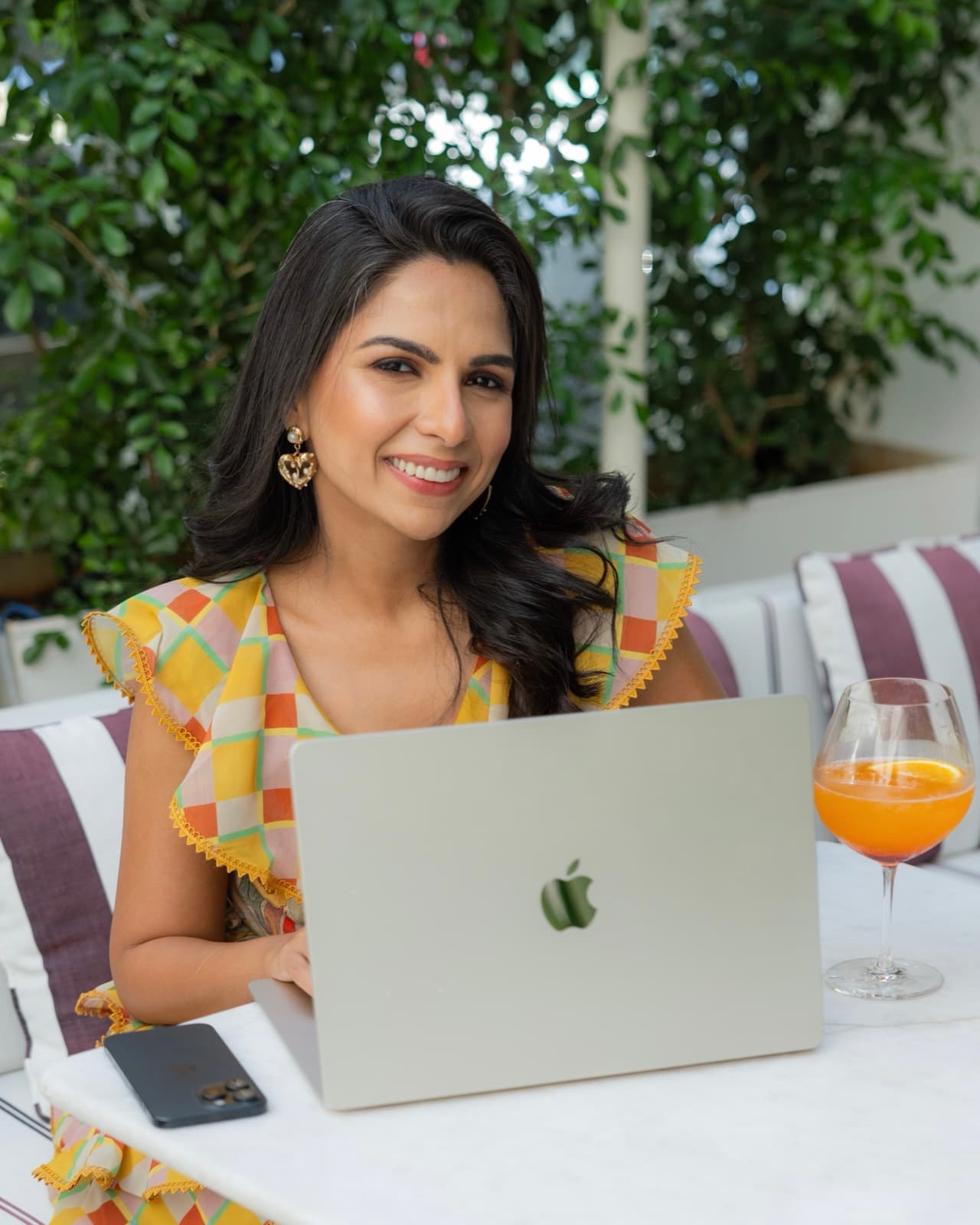 Karishma with a laptop and an aperitivo
