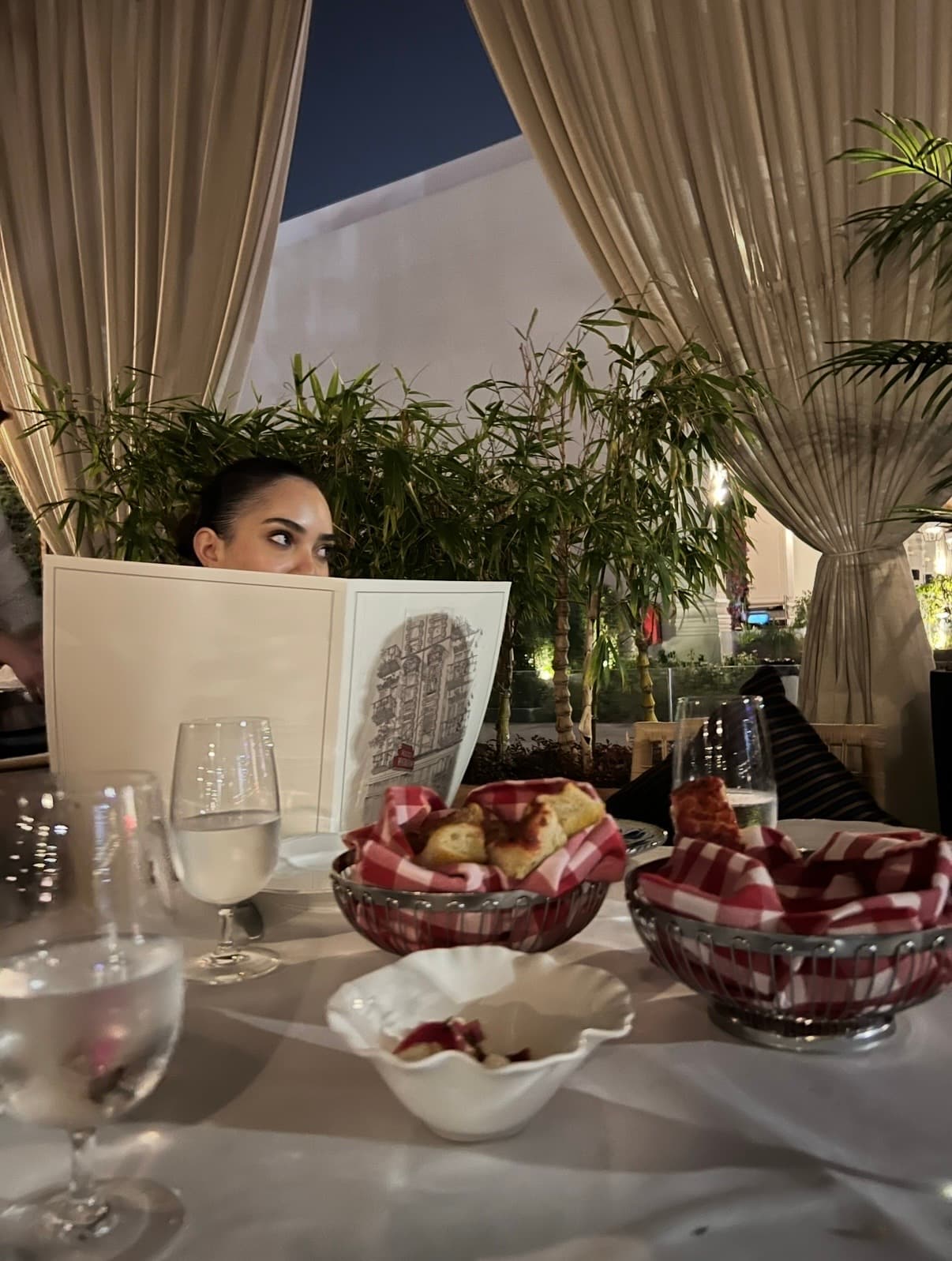 Nada peeking over a menu at a terrace table