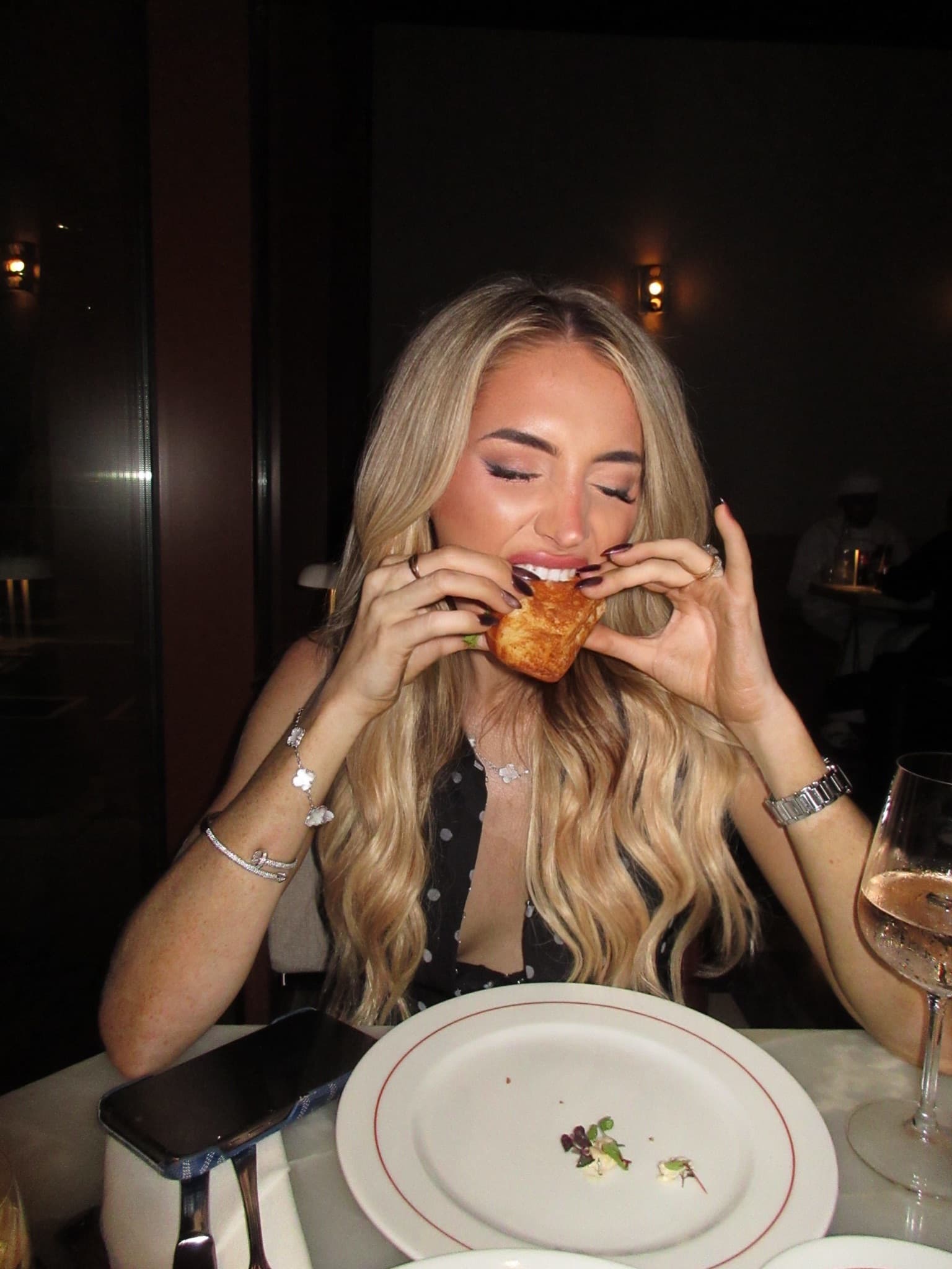 Orla taking a two-handed bite of a pastry