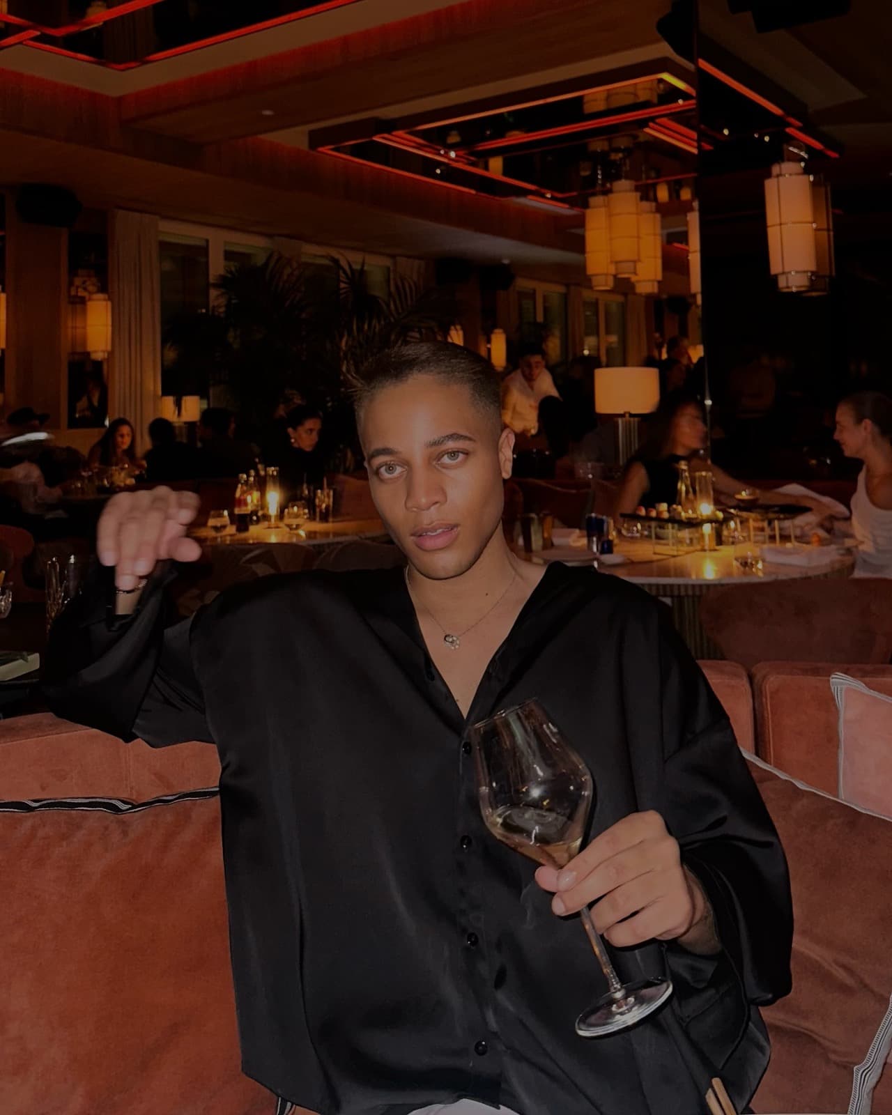 Ty on a terracotta sofa with a wine glass