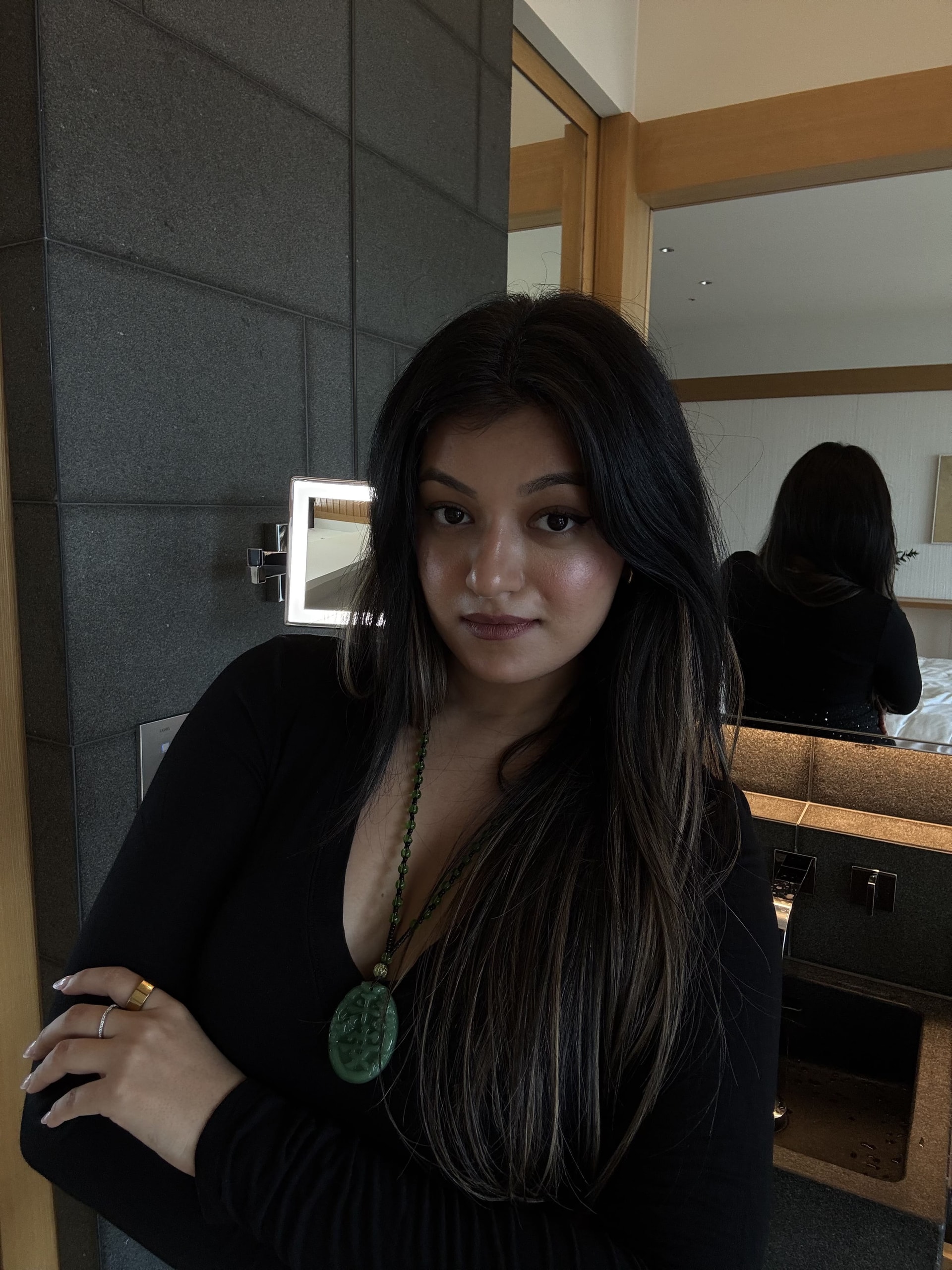 Vama in the mirror, black top and jade pendant