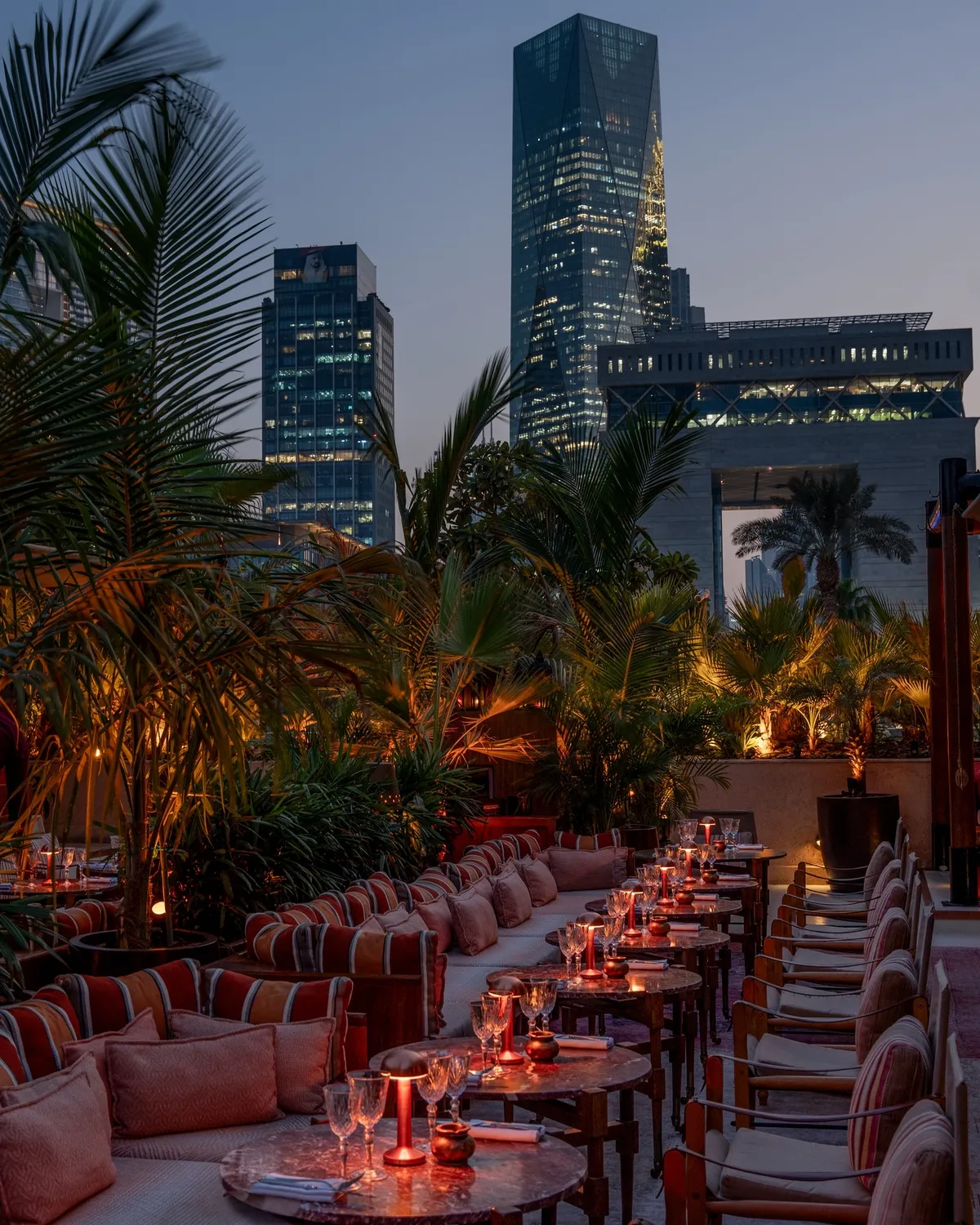 The terrace at dusk, palms framing the DIFC Gate building
