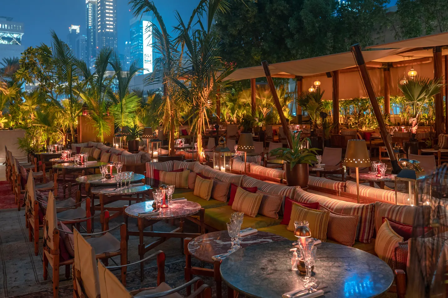 Striped sofas, low tables and palms on Ninive's open-air terrace